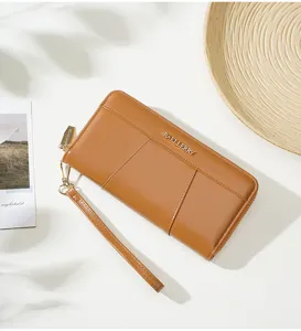 Detail view of solid brown women long clutch wallet, featuring zipper pocket and wrist strap.
