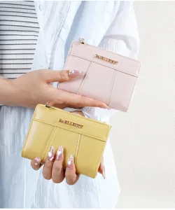 Detail view of mini PU leather wallet with card slots and zipper in pink and yellow colors.