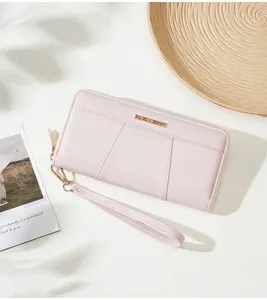 Detailed view of a stylish pink long wallet with wrist strap, elegant daily accessory.
