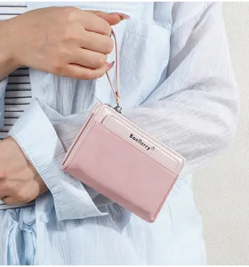 Close-up detail of women's pink short zipper wallet with wrist strap and card slots.
