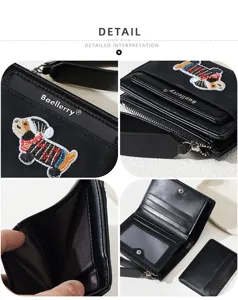 Close up view of black leather wallet detail showing cute dog embroidery and card slots.
