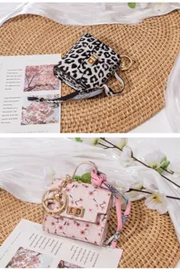 Detailansicht der Mini-Taschenanhänger mit Leoparden- und Kirschblütenmuster sowie Seidentuch.