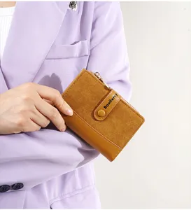 Detail view of a compact short women wallet in camel brown color with snap button and zip.
