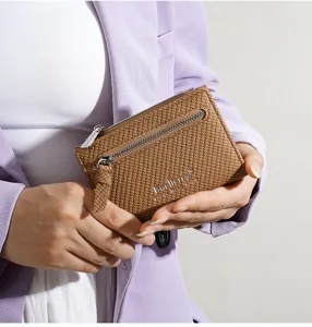Detailed view of women's short textured zipper wallet in brown, compact and stylish design.