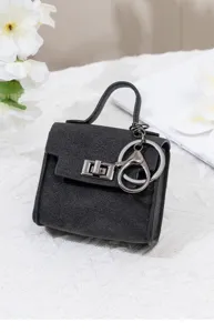 Mini schwarze Leder Handtasche Schlüsselanhänger Detailansicht mit Metall Drehverschluss.