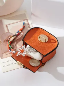 Mini portachiavi borsa sella arancione, elegante custodia cuffie in pelle e portamonete chic.