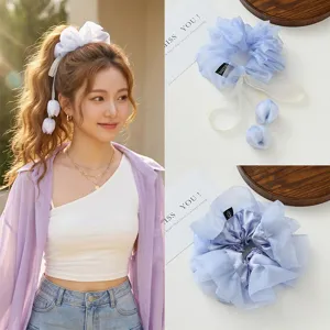 Λεπτομερής εικόνα του ανοιχτό μπλε scrunchie μαλλιών από οργάντζα με κρεμαστό τουλίπα και κορδέλα.
