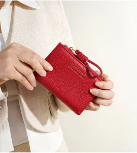 Vue détaillée d'un petit portefeuille rouge en cuir texturé avec fermeture éclair.