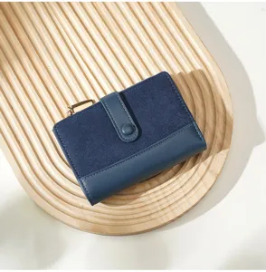 Detail shot of a navy blue color-block short wallet with snap button and zipper coin pocket.
