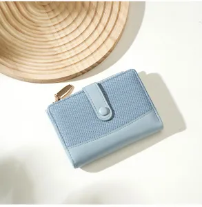 Light blue short women's wallet with woven contrast leather design and snap closure detail.