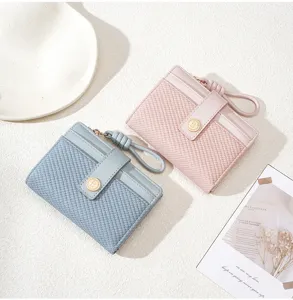Detail view of women's bifold short wallet with card slots, braided texture, and wrist strap.
