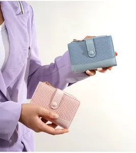 Close-up of stylish short wallets in blue and pink with woven texture and snap closure.