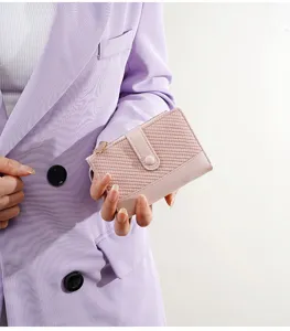 Detail view of women's short wallet with woven texture, color-block design and snap button.