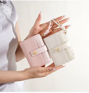 Detail shot of women short bifold wallet with woven texture and wrist strap for daily use.