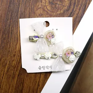 Close-up detail of cute Korean style bow hair clips with pearls, crystals, and lace.