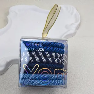 Primo piano dettagliato di elastici per capelli intrecciati blu e argento in scatola.