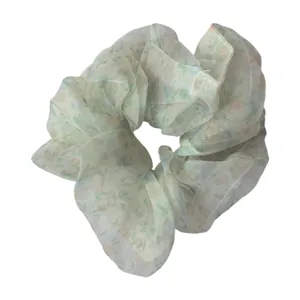 Sheer floral hair scrunchie detail view, lightweight chiffon fabric ponytail holder accessory.