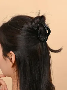 Black hair claw clip detail shot, simple minimalist design for daily elegant hair styling.