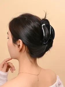 Close-up shot of elegant black acrylic hair claw clip styling on woman back head.