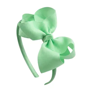 Mint green grosgrain ribbon hair bow headband, cute children hair accessory detail shot.