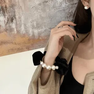 Chouchou de cheveux en velours noir avec perles de taille graduee, accessoire chic et mode.