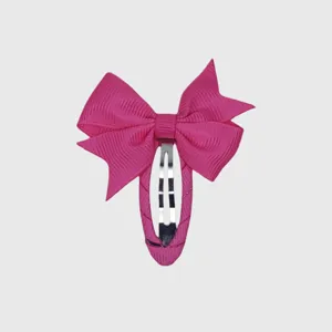 Detail view of pink bow hair clip, cute fabric wrapped snap hairpin for girls daily styling.