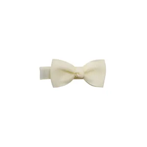 Detailed close-up of a soft cream handmade bow hair clip showing fine ribbon texture.