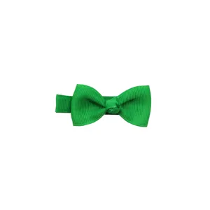 Green bow hair clip detail shot, featuring fabric ribbon material and solid color design.