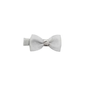 Closeup view of solid color grosgrain bow hair clip, delicate fabric handmade infant detail.