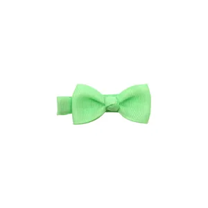 Close-up detail of a cute light green bow hair clip for baby girls, handmade fabric hairpin.