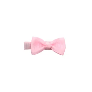Close-up detail of the pink fabric bow hair clip featuring a soft texture and secure grip.