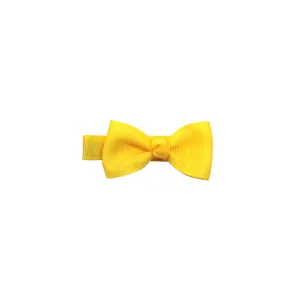Close-up detail of the bright yellow grosgrain ribbon hair bow clip, solid color design.