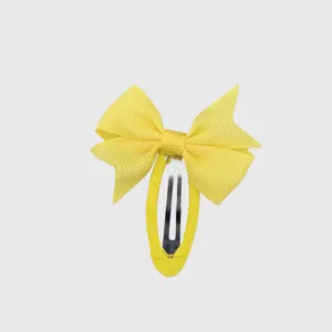 Yellow bow hair clip detail shot, fabric wrapped snap clip, cute pastoral style hair accessory.