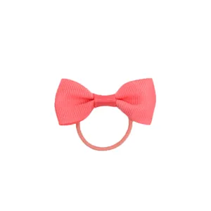 Primo piano dettagliato dell'elastico per capelli con fiocco rosa, consistenza del tessuto.