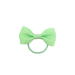 Vista dettagliata elastico capelli con fiocco verde chiaro, accessorio per bambini.