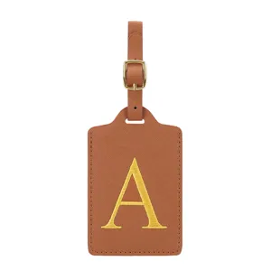 Détail d'étiquette de bagage en cuir PU marron avec lettre A brodée jaune et boucle