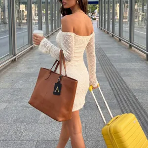 Nahaufnahme des eleganten schwarzen Leder-Gepäckanhängers mit goldenem Buchstaben an der Tasche.