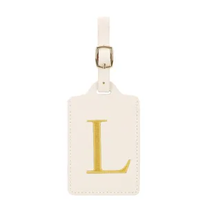 Élégante étiquette de bagage en cuir beige avec une lettre L brodée d'or pour vos voyages.