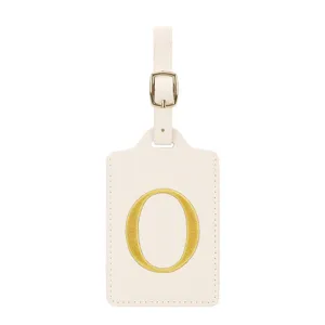 Vue détaillée de l'étiquette de bagage en cuir beige avec boucle dorée et lettre brodée O.
