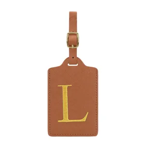 Vue détaillée d'étiquette de bagage en cuir PU marron avec boucle dorée et lettre L.