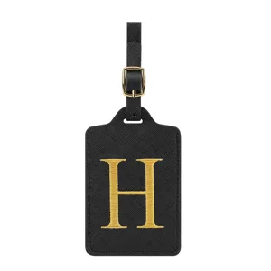 Nahaufnahme des schwarzen PU-Leder-Gepäckanhängers mit elegantem goldem Monogramm-Buchstaben H.