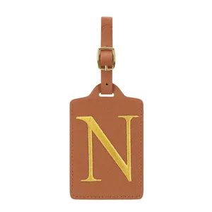 Étiquette de bagage en cuir PU marron avec lettre N brodée dorée et boucle métallique.