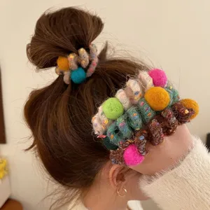 Winter woolen wrapped phone wire hair tie with pom poms, elastic ponytail holder accessory.