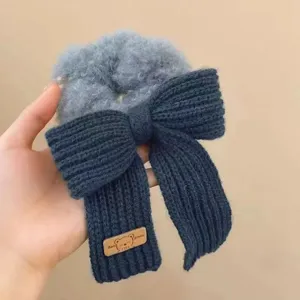 Gros plan d'un chouchou à nœud tricoté bleu foncé mignon avec une texture pelucheuse.