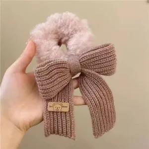 Vue détaillée d'un chouchou en peluche douce et nœud en tricot, élastique de cheveux.