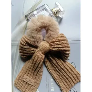 Gros plan détail de chouchou en peluche duveteuse et nœud en tricot marron, accessoire de coiffure.