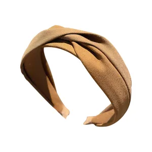 Detail shot of a vintage wide fabric knotted headband in camel, stylish daily hair hoop.