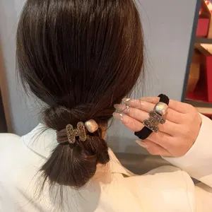 Close-up detail of rhinestone H-letter elastic hair tie and pearl charm, elegant hair acc.
