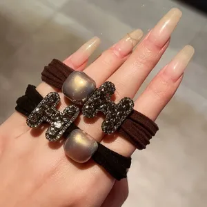 Detailed close-up of rhinestone H hair ties, elegant elastic hair rope, charming accessory.