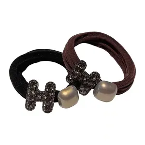 Detailed view of rhinestone H design hair ties, elegant black and brown elastic hair ropes.